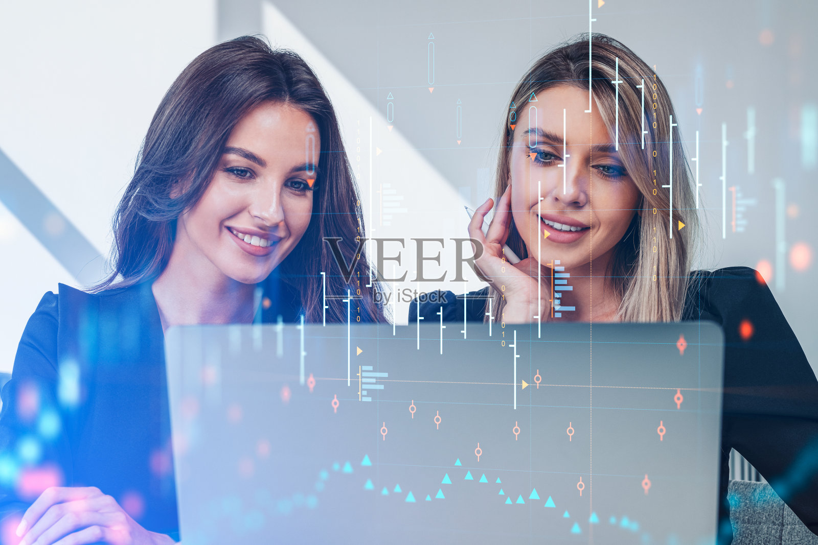 女商人们用笔记本电脑、外汇图表、全息图一起工作照片摄影图片