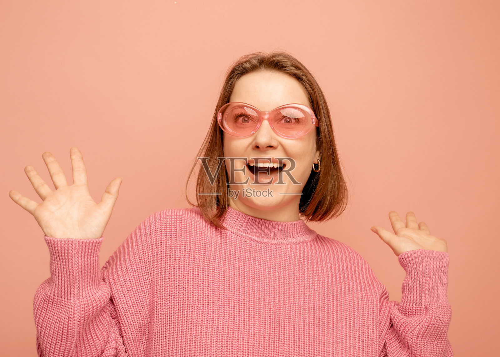 美丽的惊讶的女人在粉红色的背景照片摄影图片