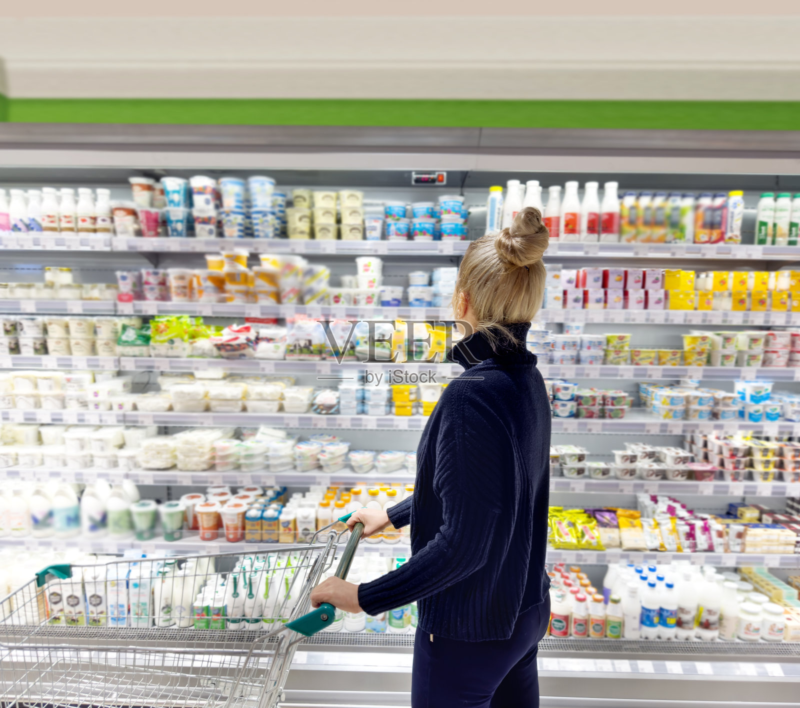 一名妇女从超市冷冻室挑选冷冻食品照片摄影图片