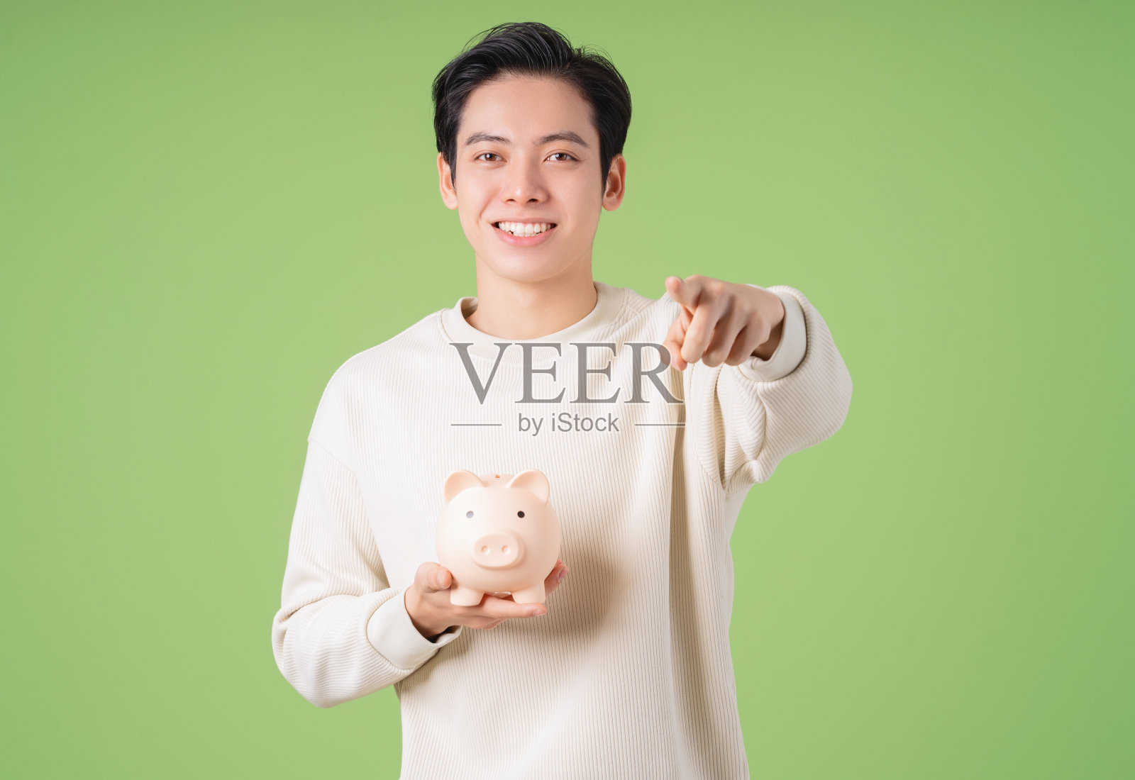 背景上年轻的亚洲男子拿着存钱罐的图像照片摄影图片