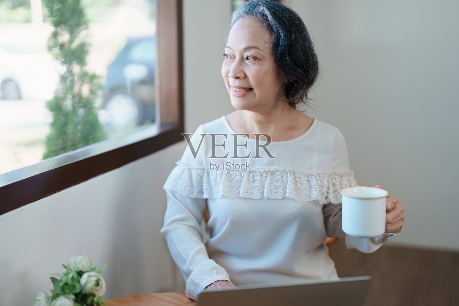 做电脑工作喝咖啡的亚洲老年妇女肖像照片摄影图片