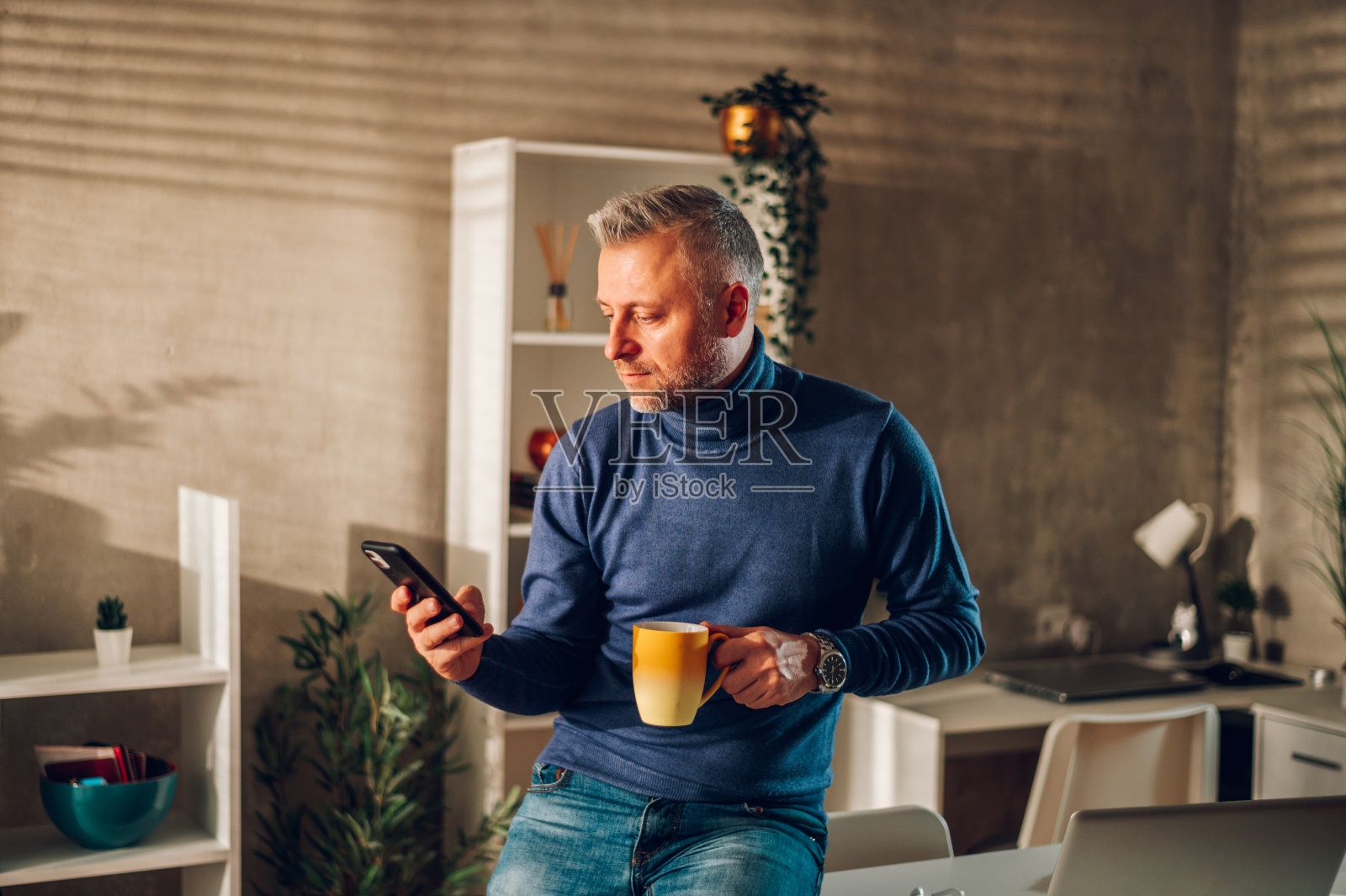 中年男人在家使用智能手机喝咖啡照片摄影图片