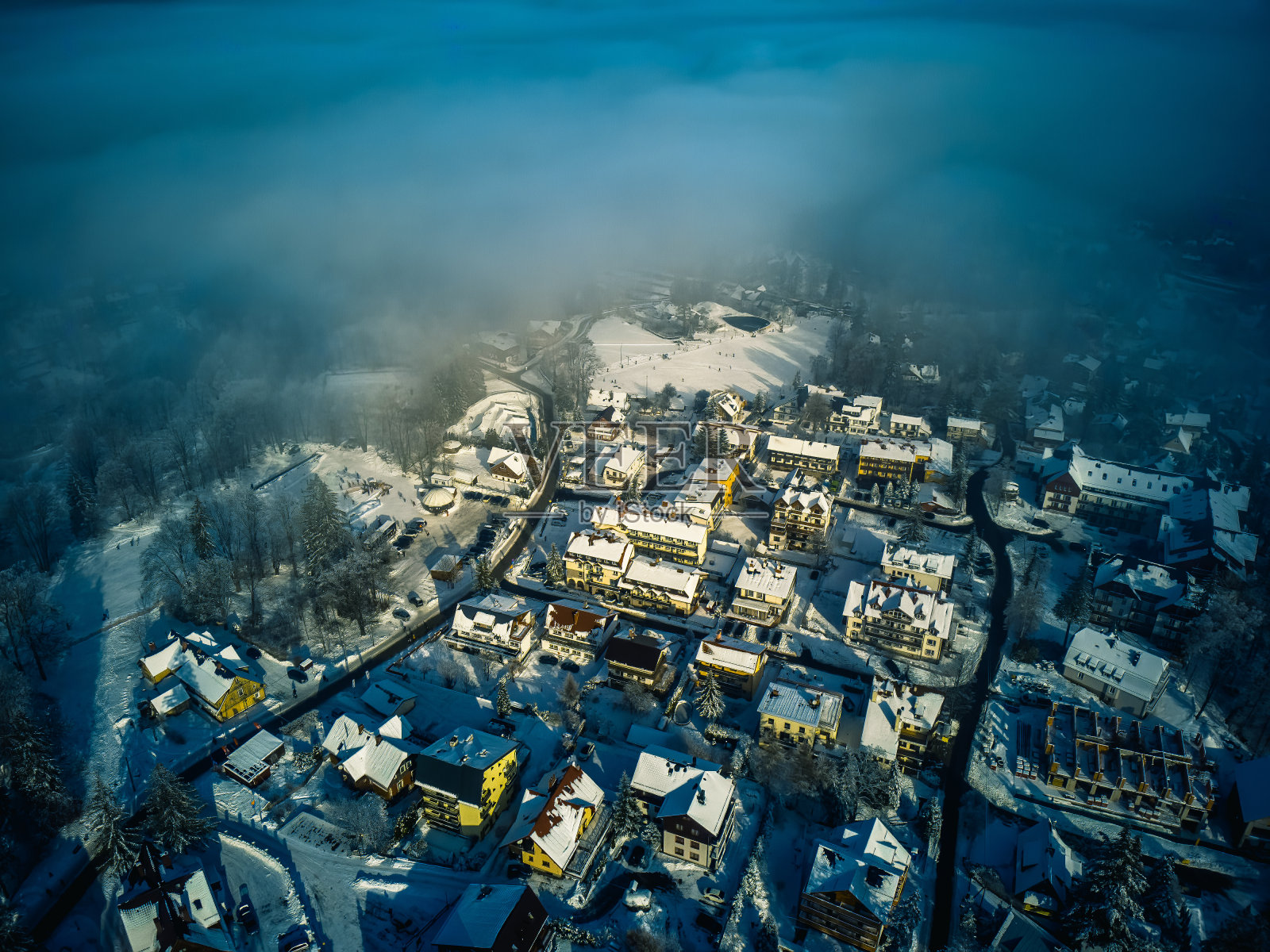 大雪覆盖的巨人山附近村庄的鸟瞰图。照片摄影图片