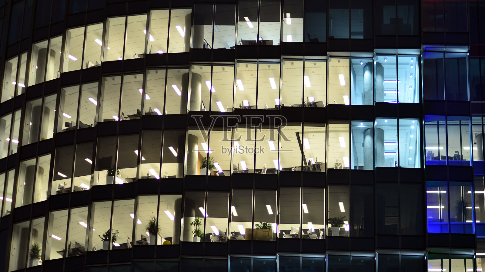城市中现代化的办公大楼在夜晚。公司建筑的照明办公室视图。照片摄影图片