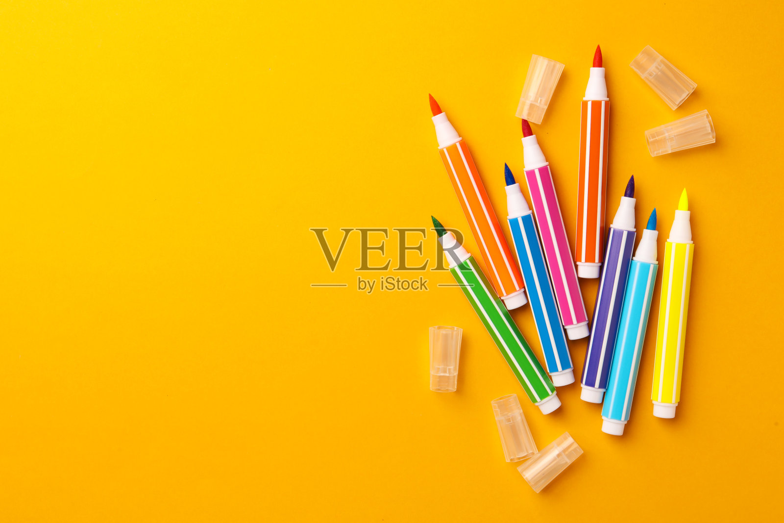 黄色背景上有许多明亮的标记，平铺。文本空间照片摄影图片