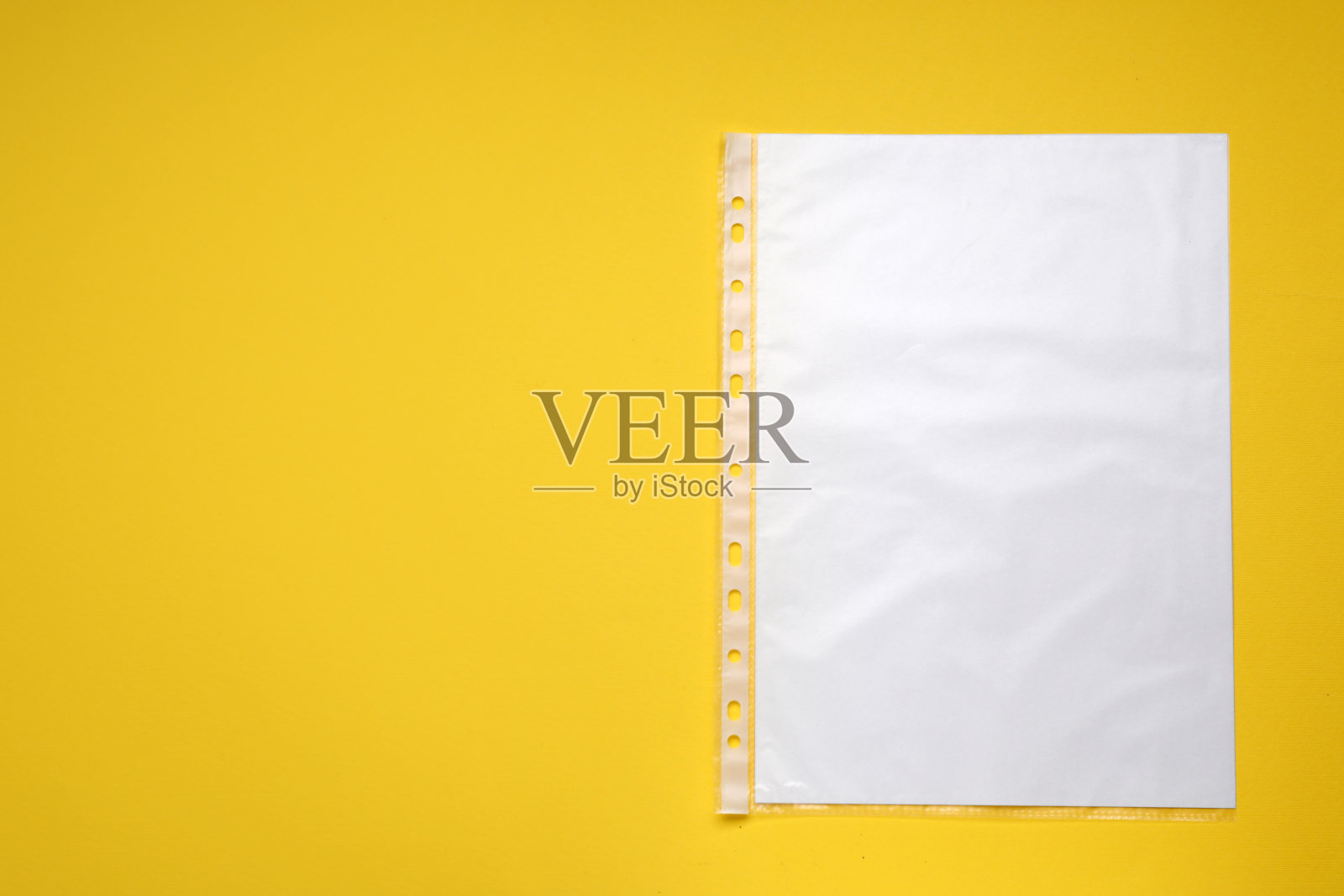 穿孔口袋与纸张在黄色背景，俯视图。文本空间照片摄影图片