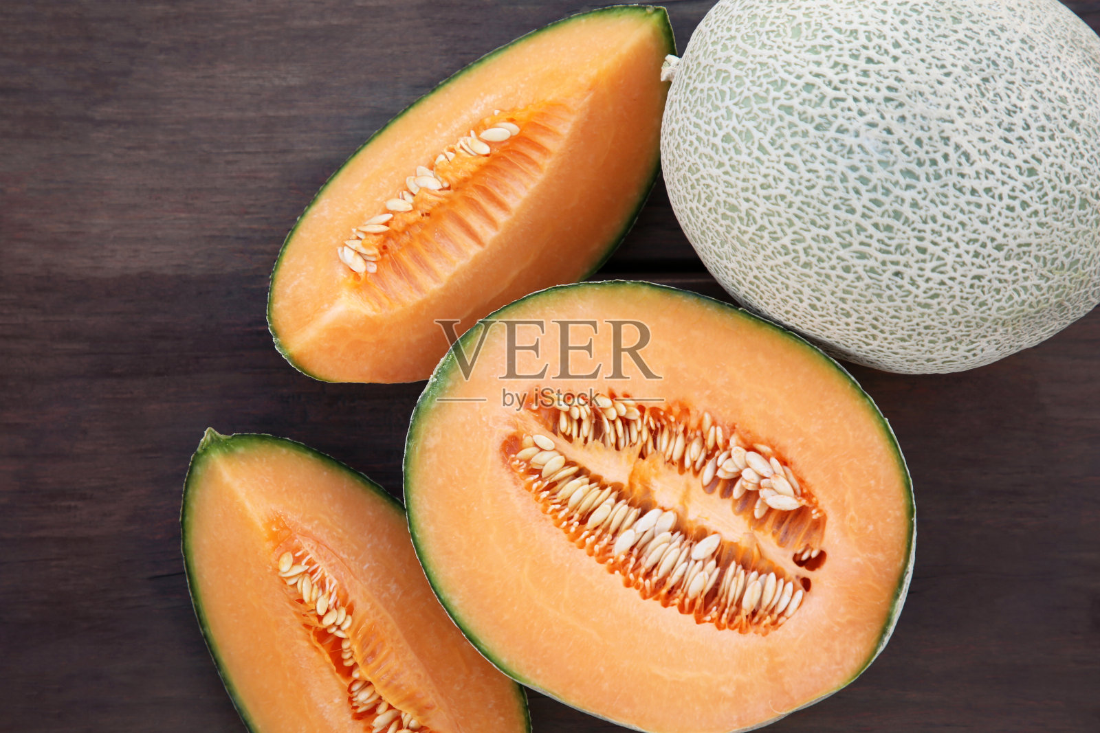 美味的橙子熟瓜放在木桌上，平放照片摄影图片