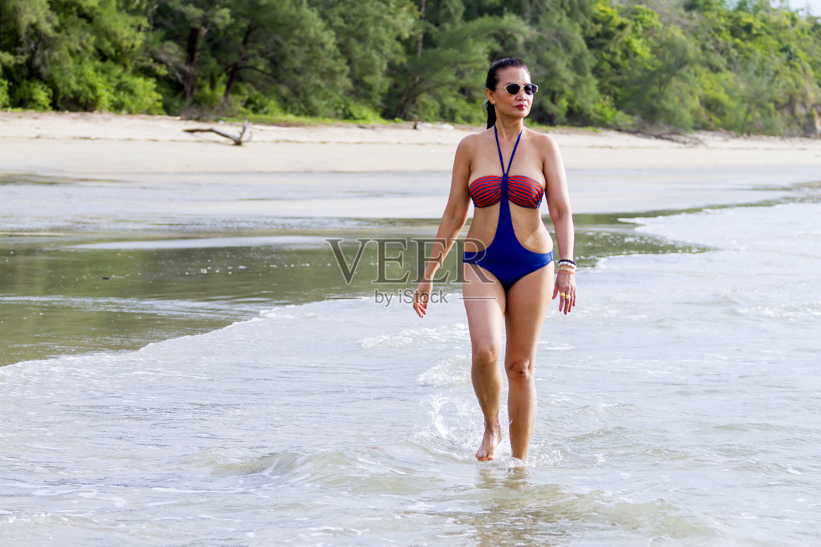 女子与泳装走在早晨的海滩照片摄影图片