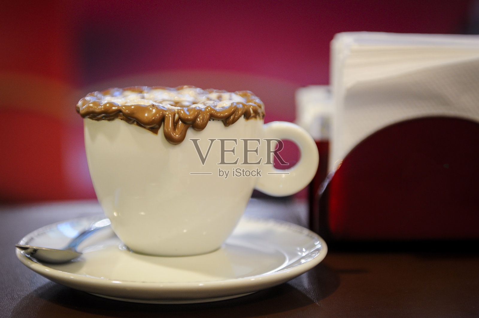 咖啡店桌上的摩卡咖啡，有选择性的焦点和模糊的红色调背景。照片摄影图片