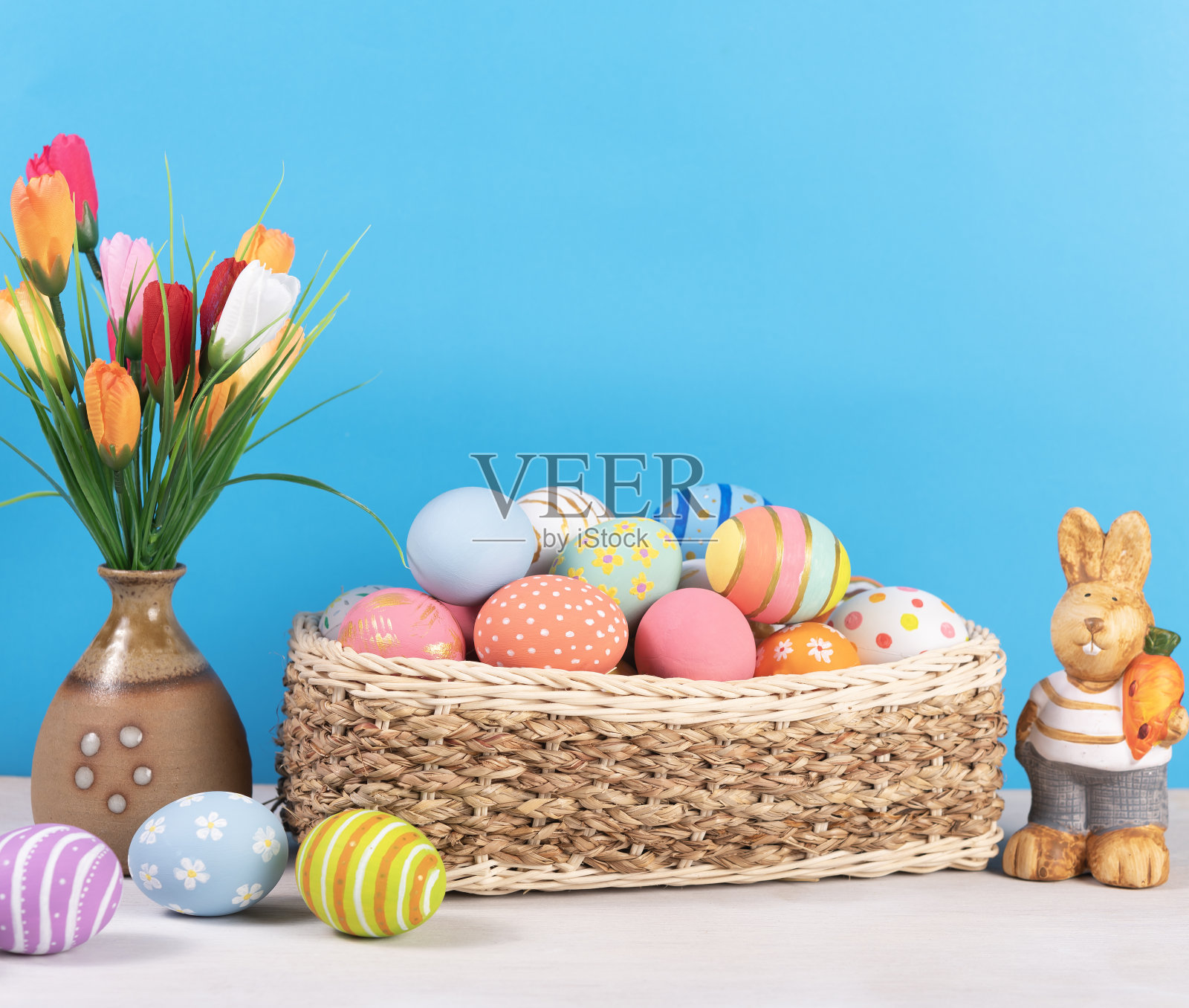 复活节快乐，复活节彩绘彩蛋放在木桌上的篮子里，供你在节日里装饰。副本的空间。照片摄影图片
