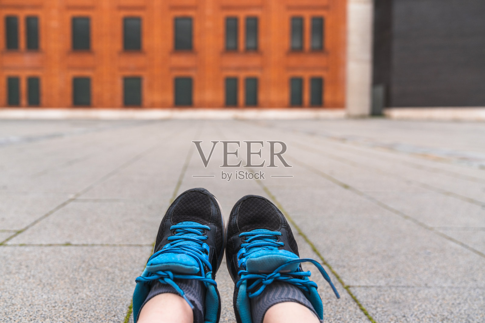 一个穿着运动鞋坐在地上的人的脚的特写镜头照片摄影图片