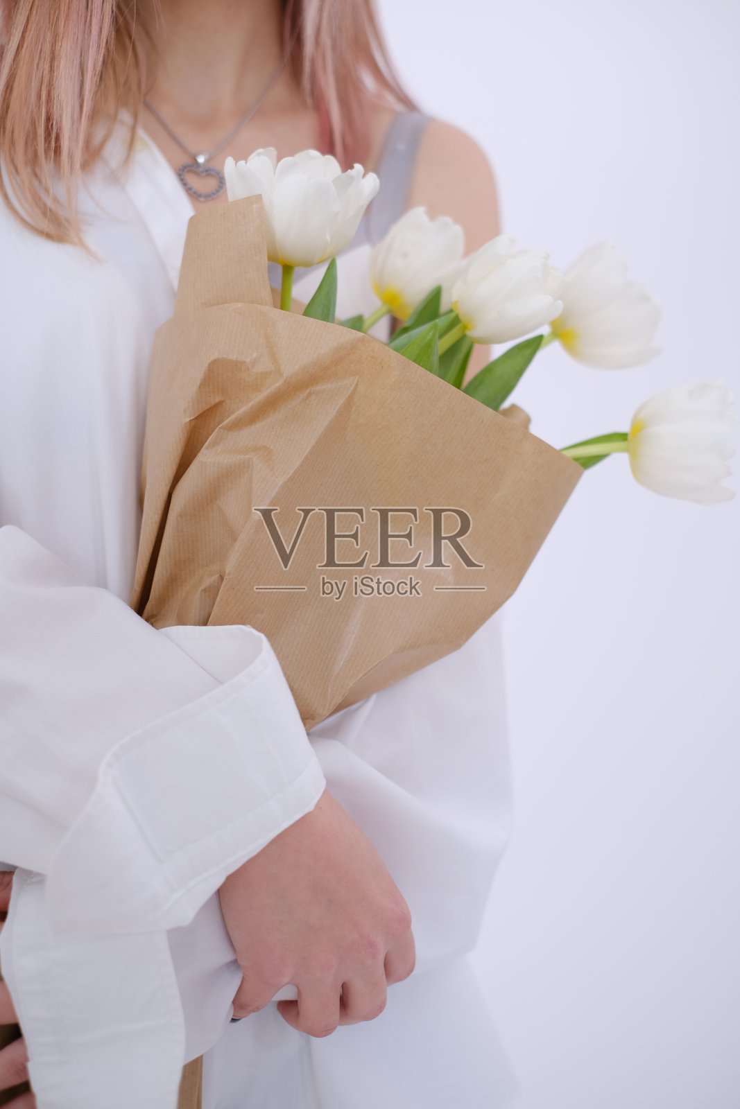 迷人的女人手里拿着一束白色的郁金香。自爱的概念。本空间照片摄影图片