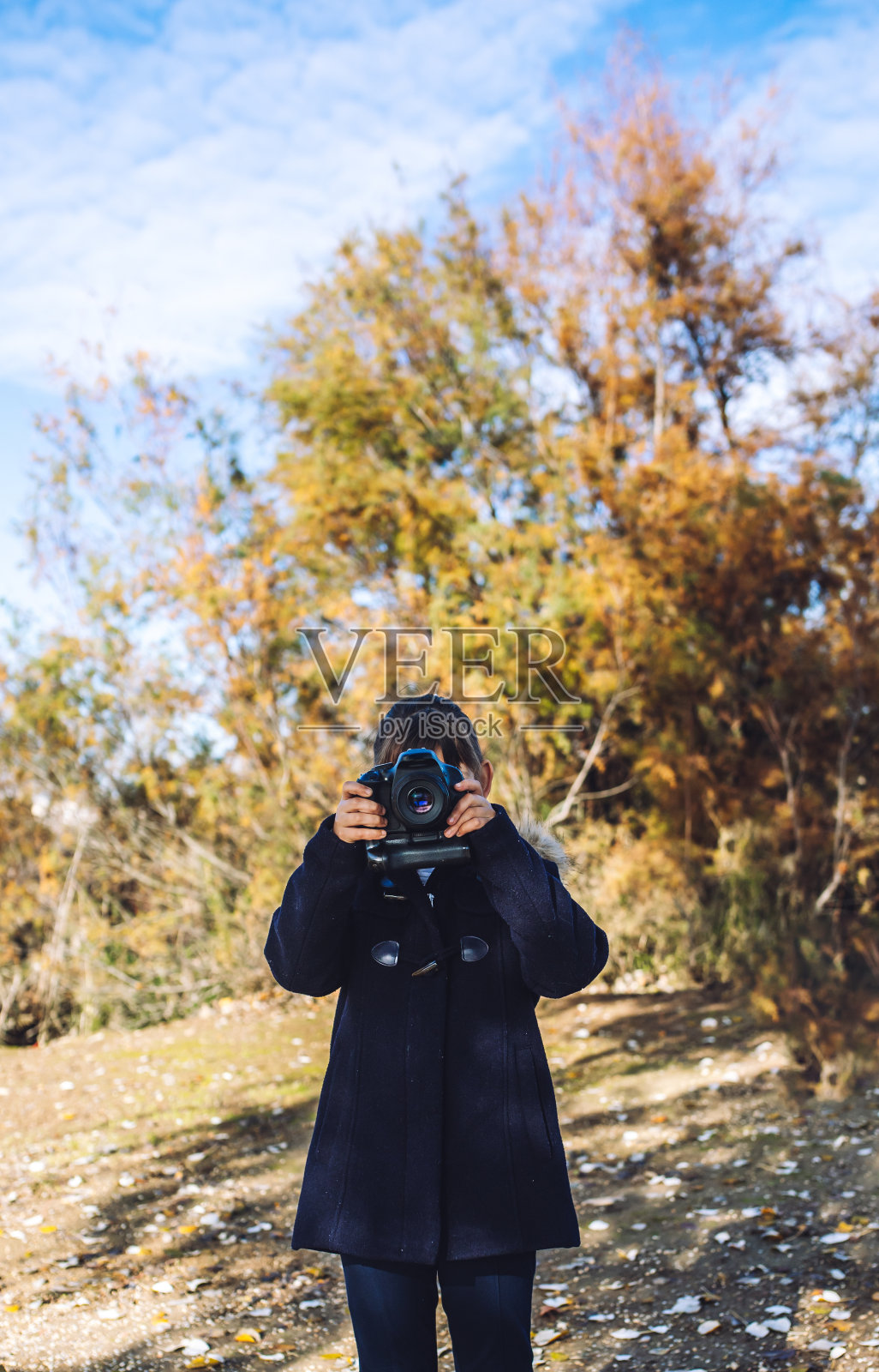 一个阳光明媚的日子里，一个白人小女孩在公园里拍照照片摄影图片