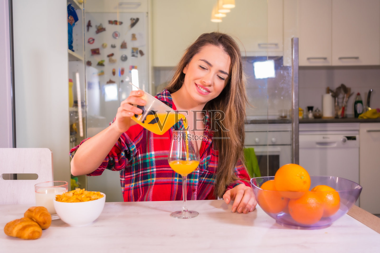 西班牙年轻女子在厨房里做橙汁照片摄影图片
