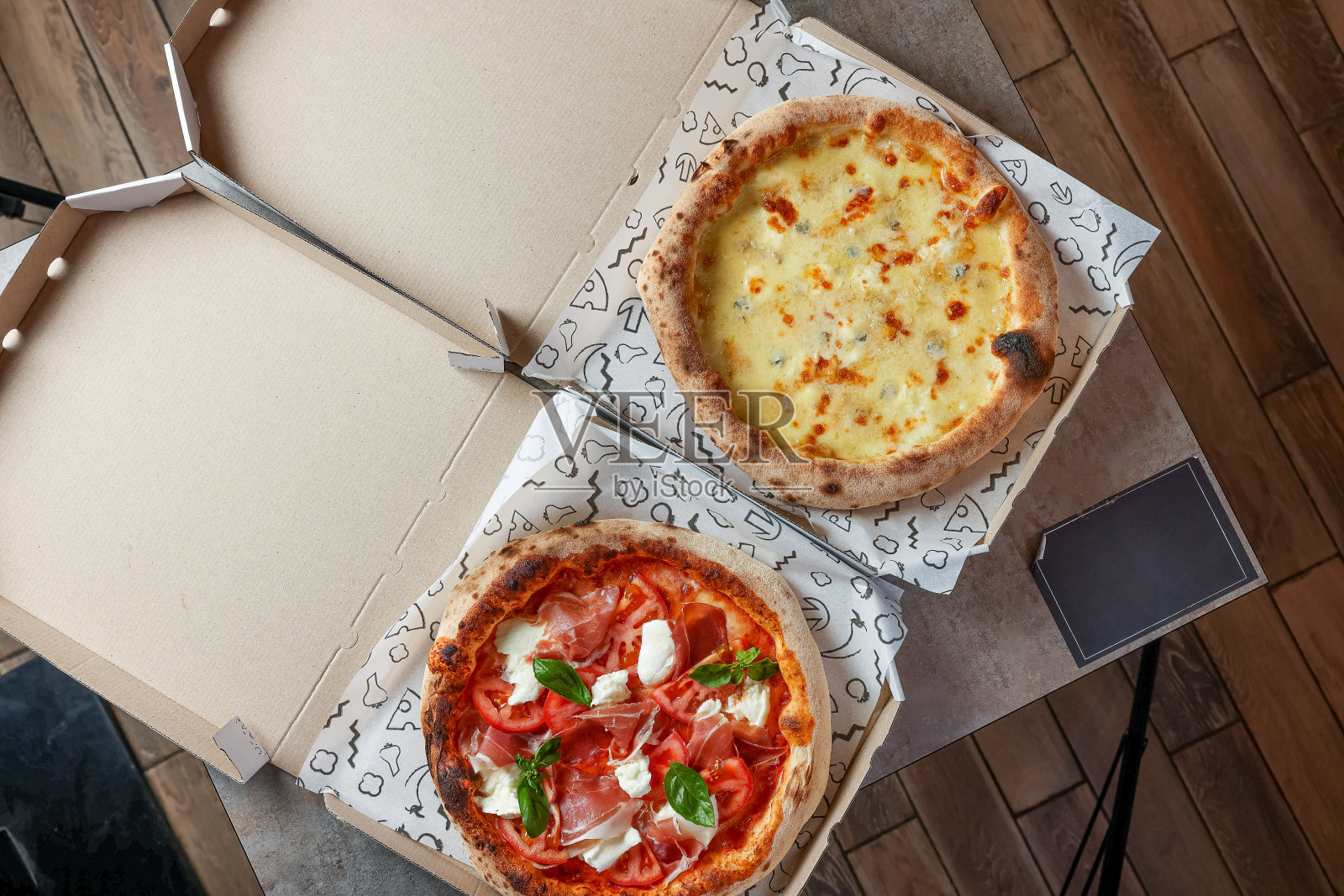 两种披萨装在打开的快递盒里照片摄影图片