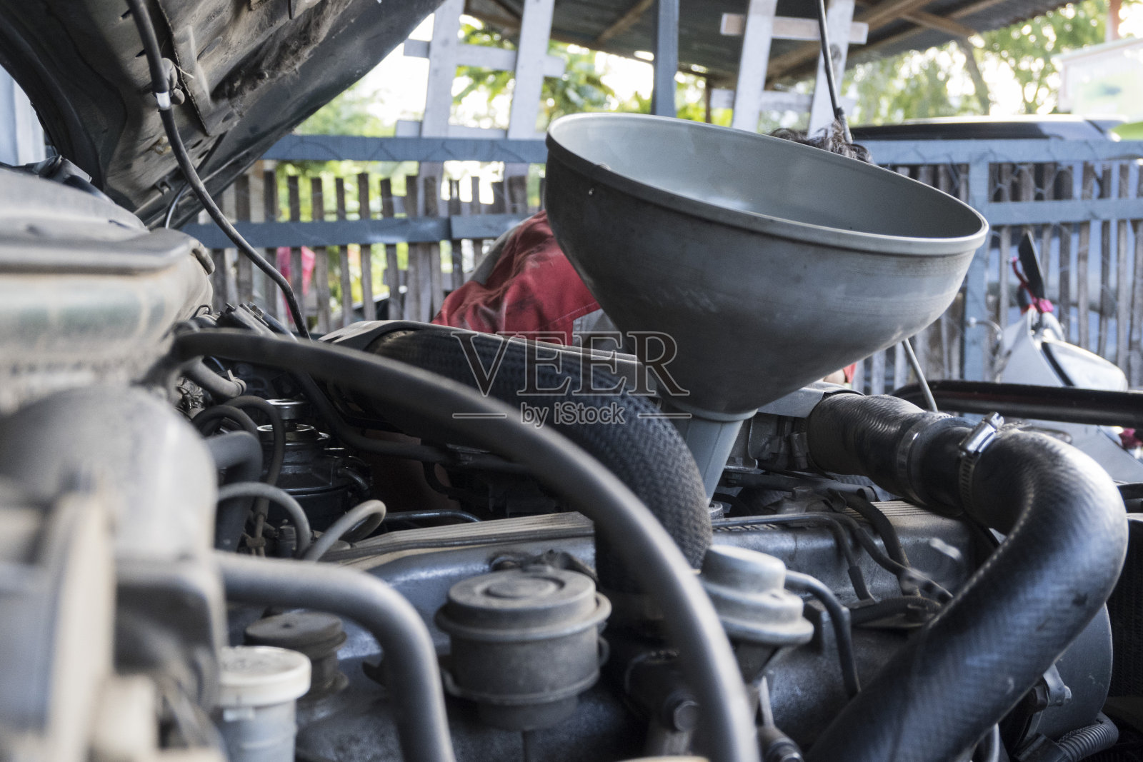 汽车机械师改变和注入新鲜的油到发动机-库存照片照片摄影图片