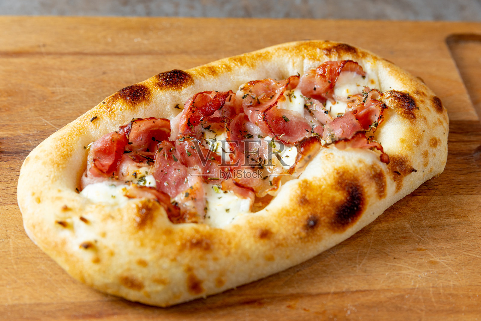 意大利熏火腿和马苏里拉奶酪放在椭圆面团上照片摄影图片