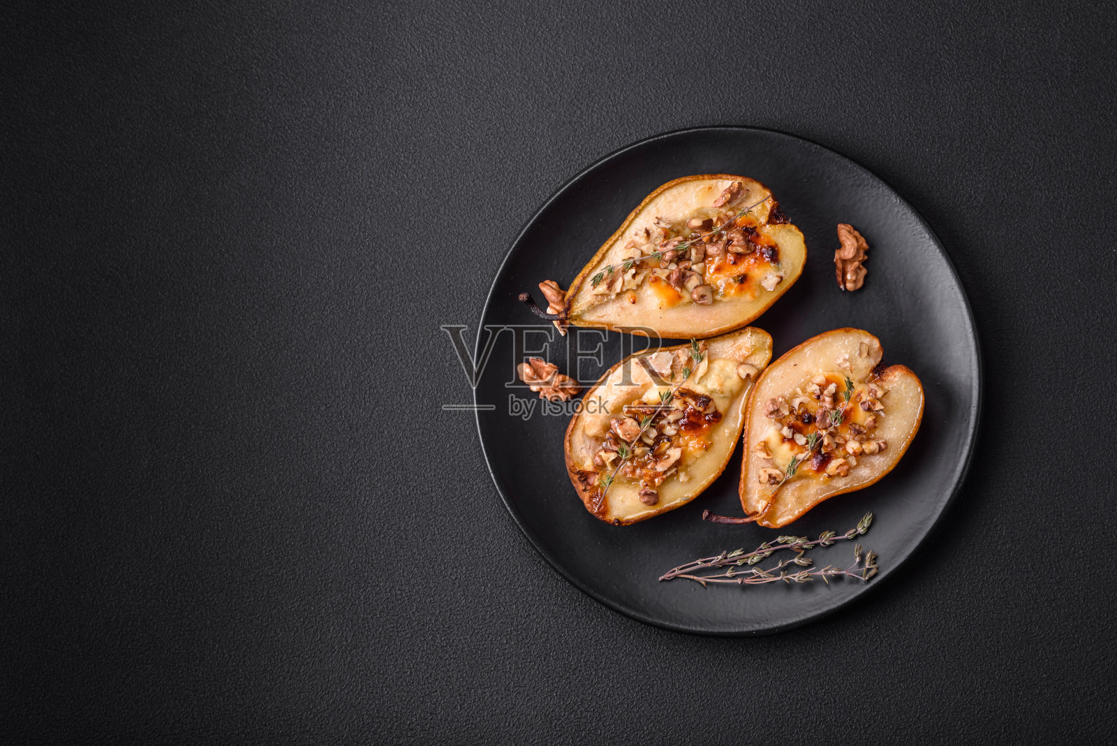 美味的烤梨，多布鲁奶酪，核桃和蜂蜜在纹理混凝土背景照片摄影图片