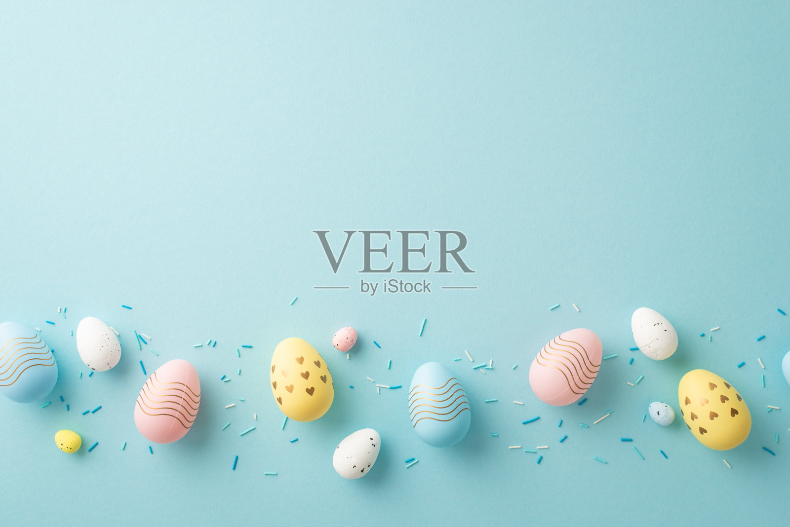 复活节的概念。顶部视图照片的彩色复活节彩蛋在排和洒在孤立的淡蓝色背景与复制空间照片摄影图片