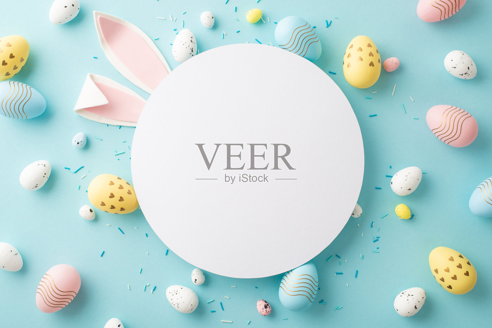 复活节的概念。顶部视图照片空圈复活节兔子耳朵黄蓝色粉色鸡蛋和洒在孤立的粉彩蓝色背景与复制空间照片摄影图片
