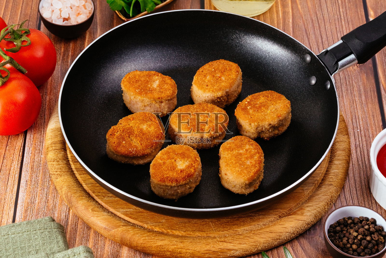 在煎锅里煎鸡块放在桌上，酱汁和ve照片摄影图片