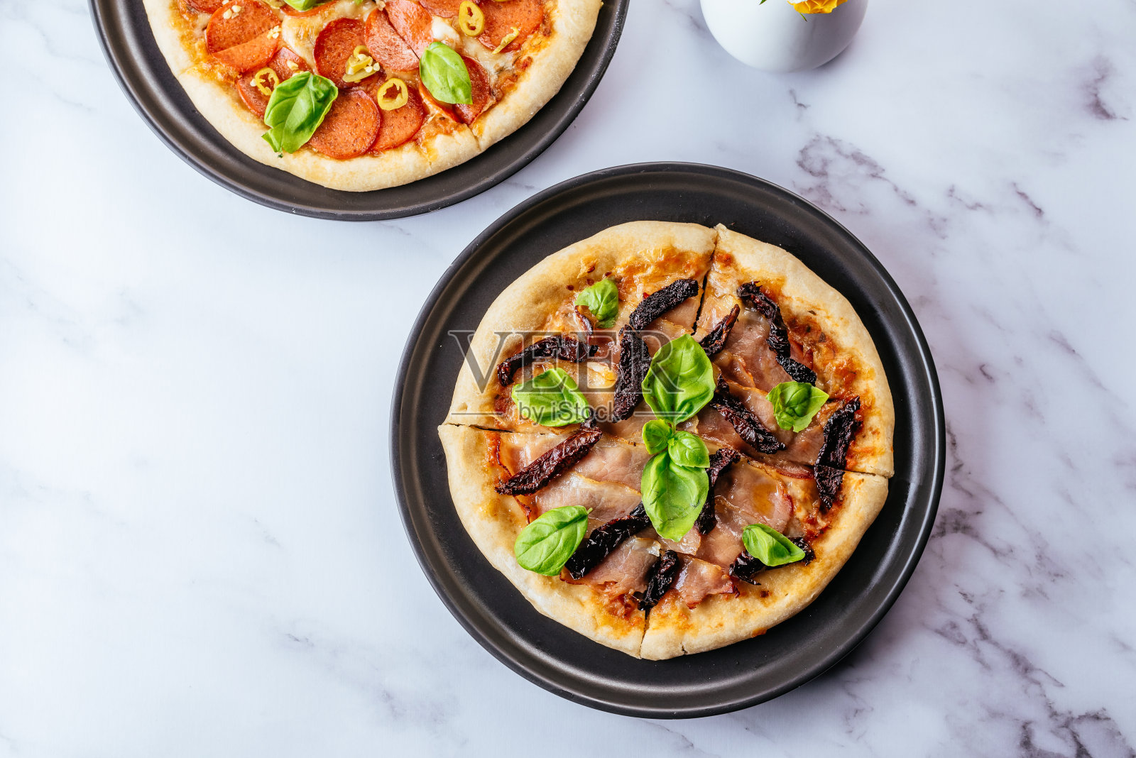 披萨、帕尔玛火腿和番茄干放在大理石桌上照片摄影图片