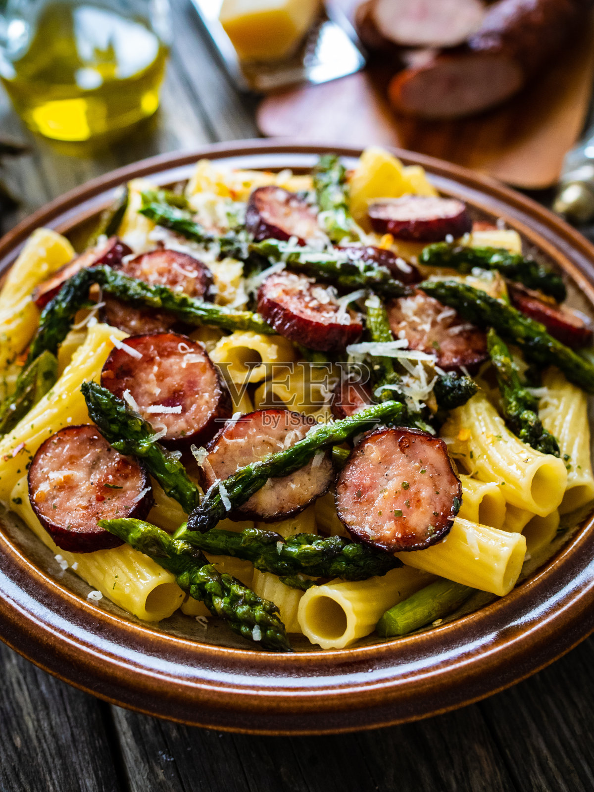 木桌上的意大利面配芦笋、帕尔玛干酪和圣女果照片摄影图片