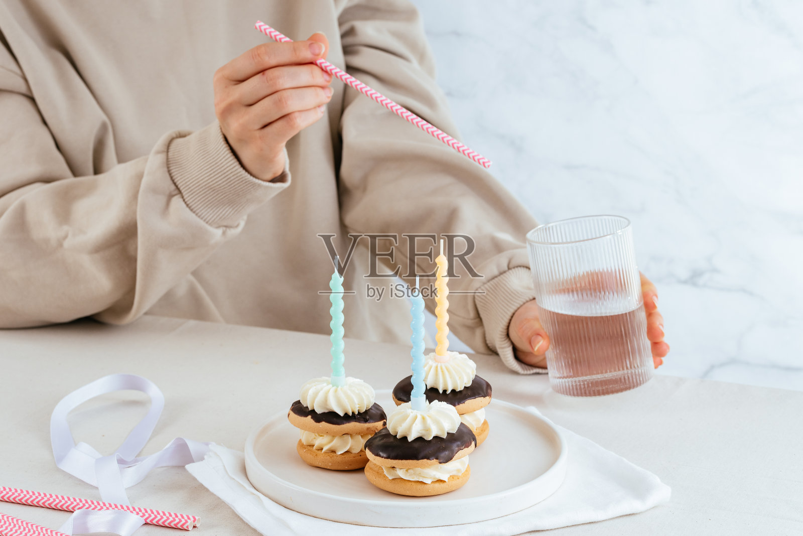 一个女孩出生时带着蜡烛，后面拿着一杯饮料照片摄影图片