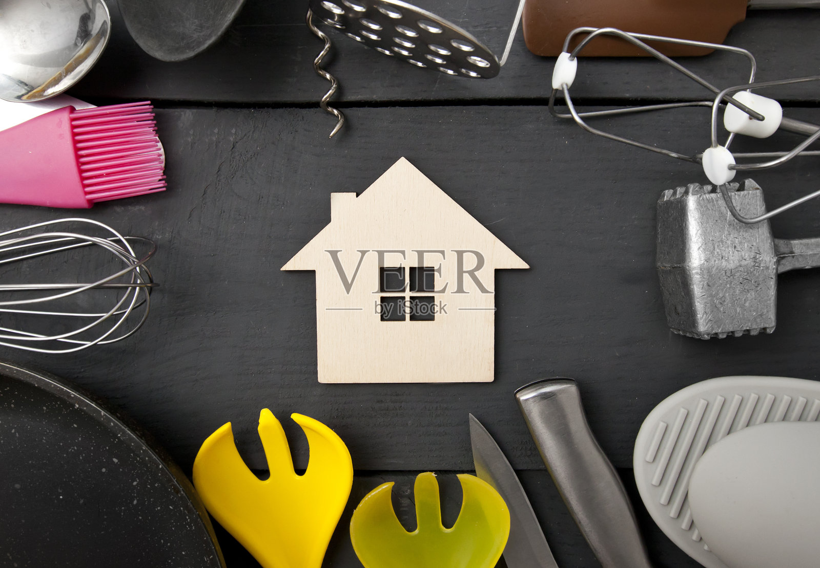 木桌上放着许多不同的厨房用具，桌子之间有一座小木屋照片摄影图片