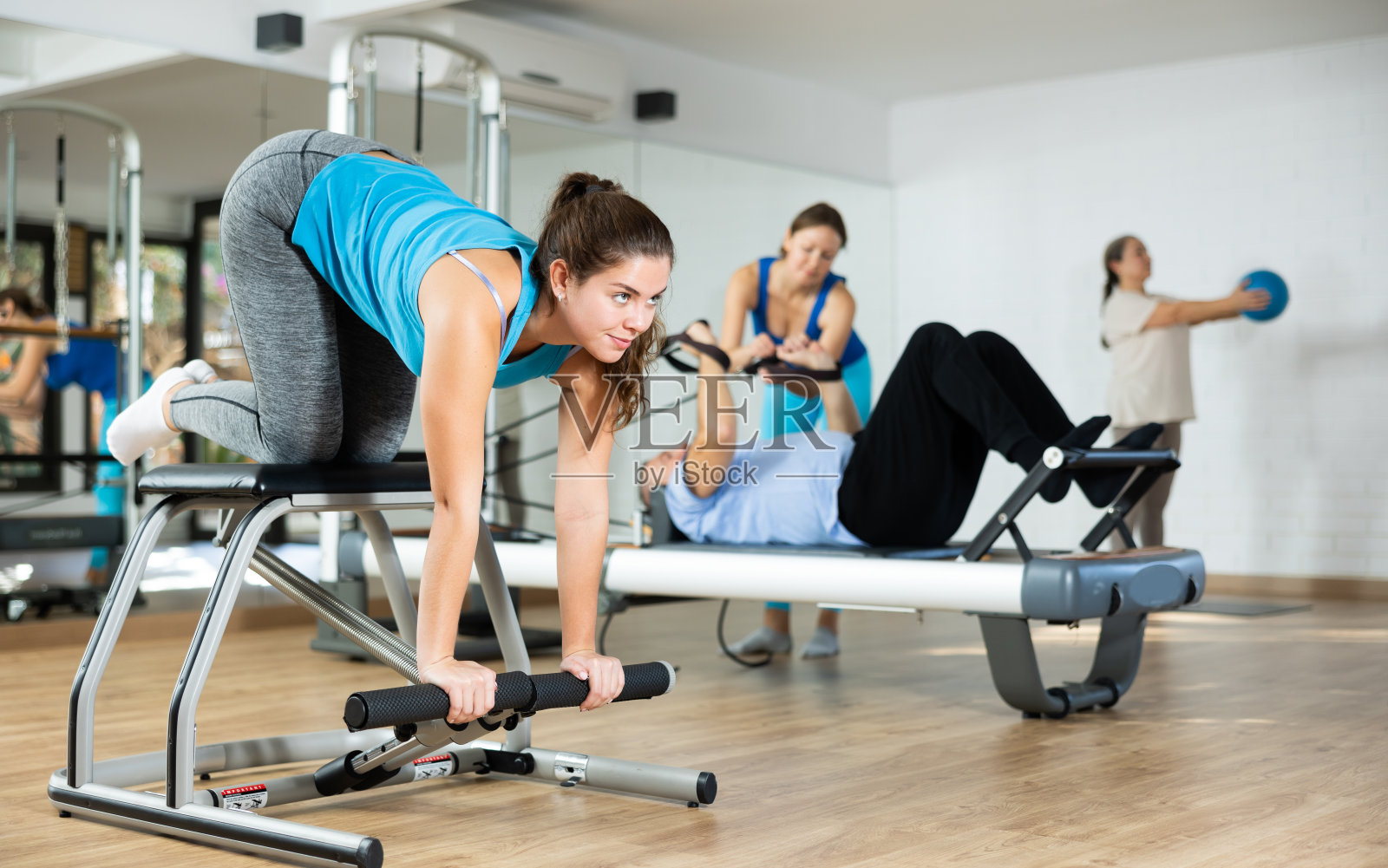 年轻女孩练习普拉提练习组合椅照片摄影图片