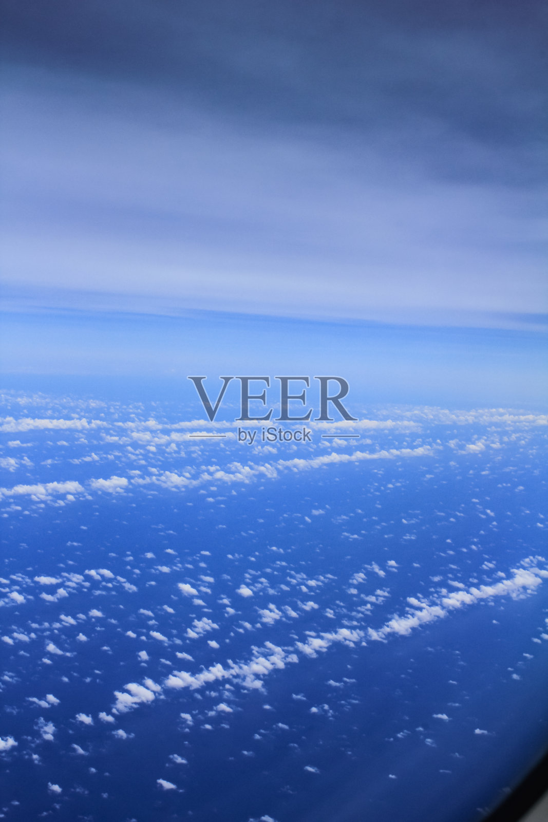 Cloudscape背景。从飞机的窗户往外看。天空中不同深浅的蓝色。照片摄影图片