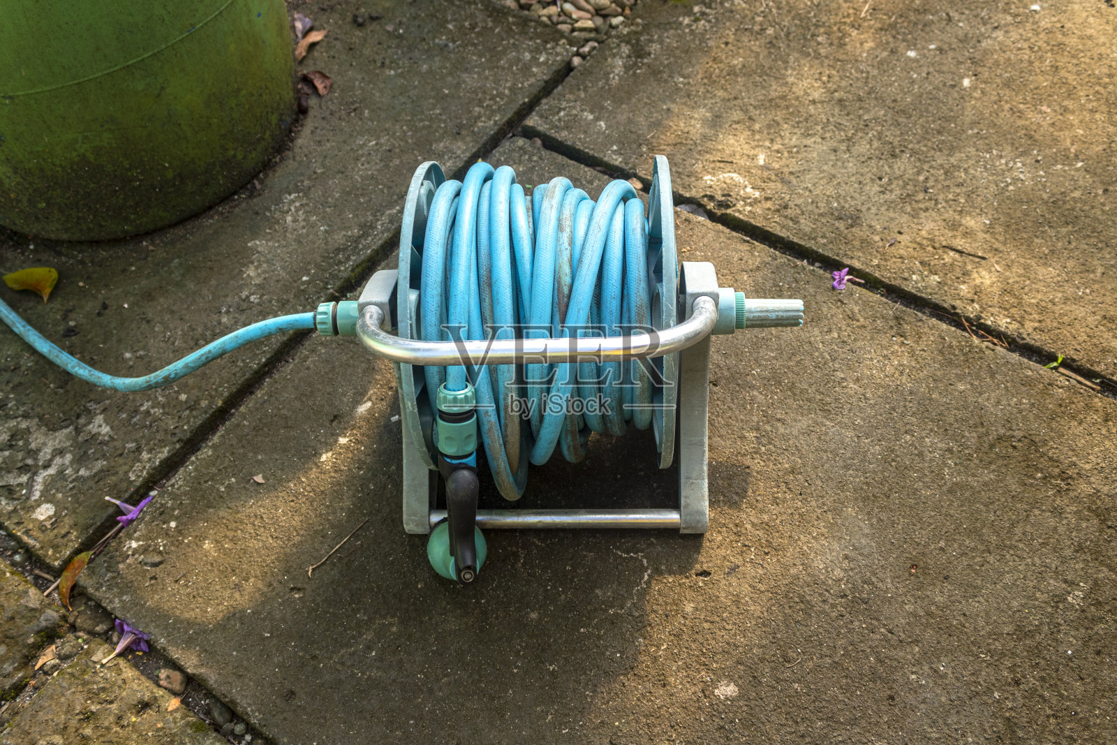 用于浇灌花园植物和花卉的花园软管卷轴和洒水器照片摄影图片