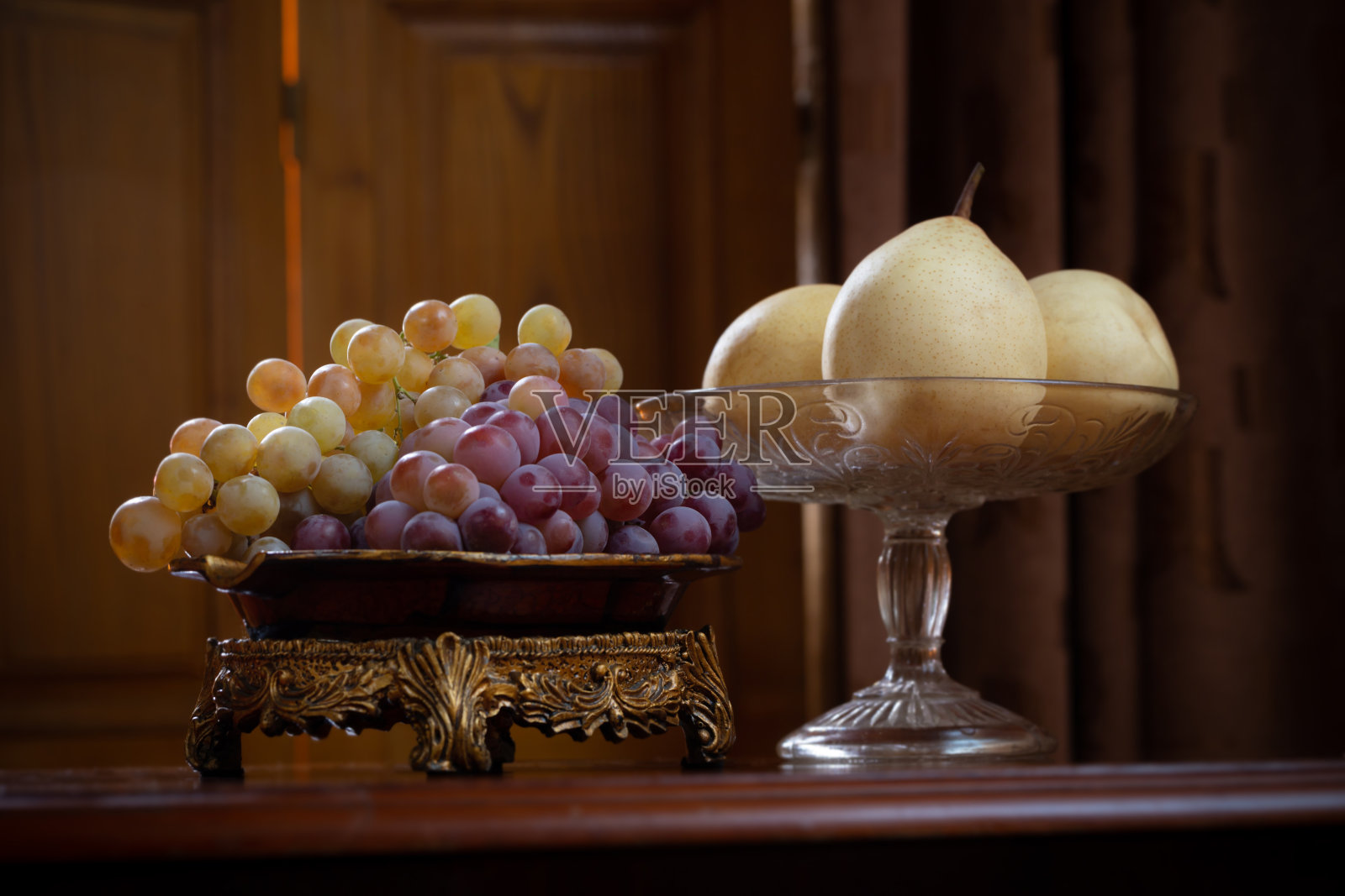 静物与盘子充满葡萄和梨在木制背景照片摄影图片