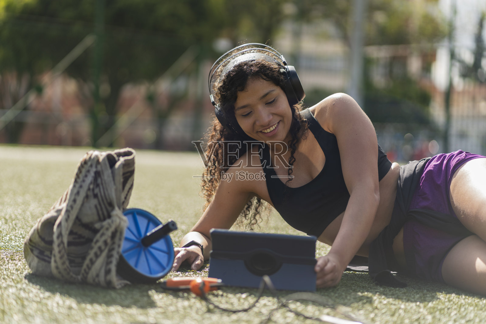 这位女士一边锻炼，一边查看平板电脑照片摄影图片
