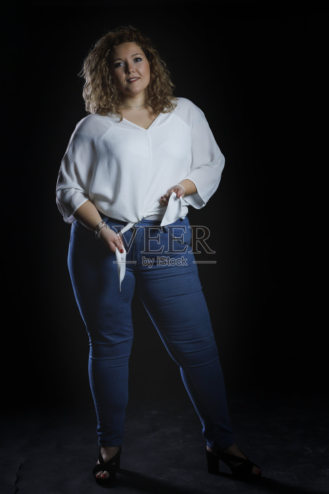 加码时装模特牛仔衣服和白衬衫在黑色背景，超重的女性身体照片摄影图片