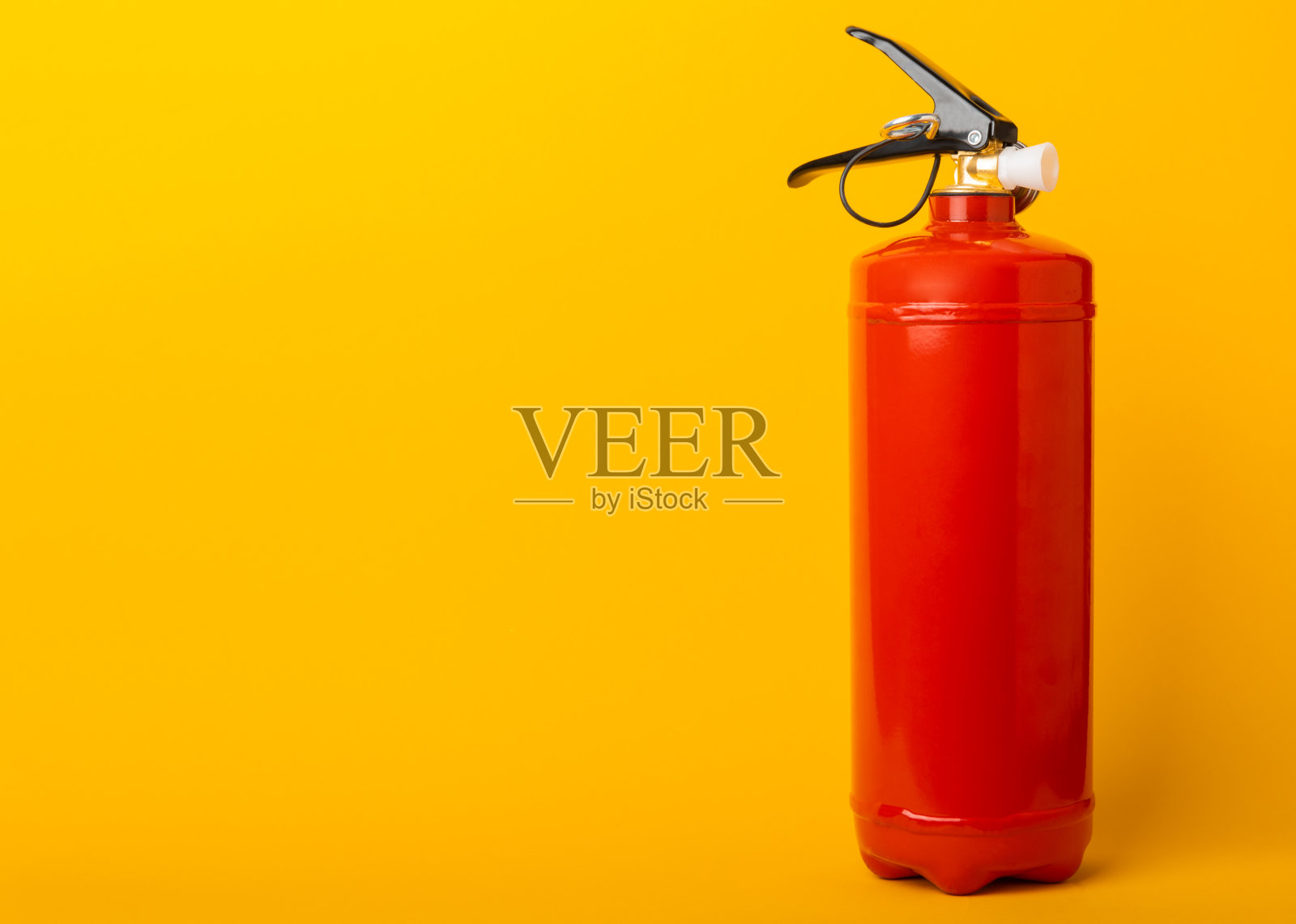黄色背景灭火器。室内墙上有红色灭火器。消防，家用灭火器。模型，文本空间，复制空间。照片摄影图片