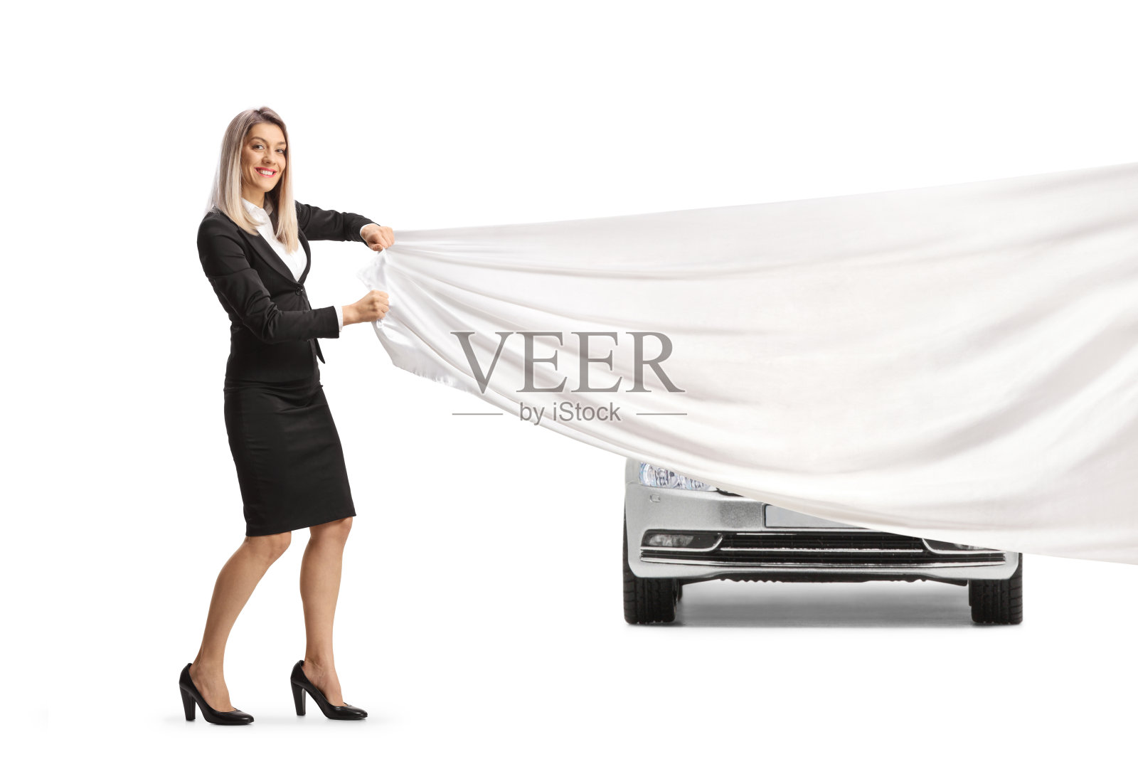 女商人在一辆新的银色汽车前拉着一块白色的布照片摄影图片