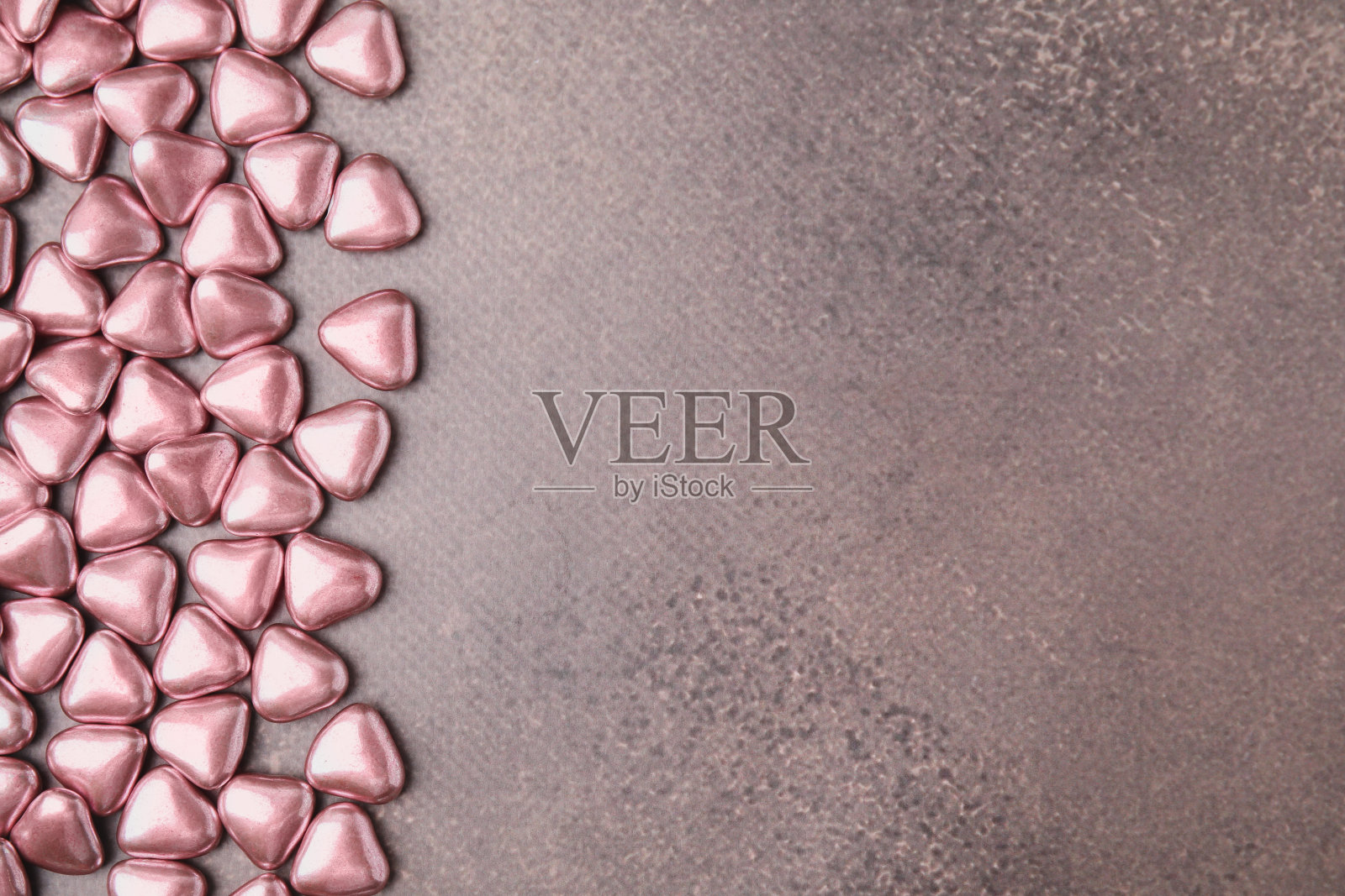 美味的心形糖果放在灰色的桌子上，平放。文本空间照片摄影图片