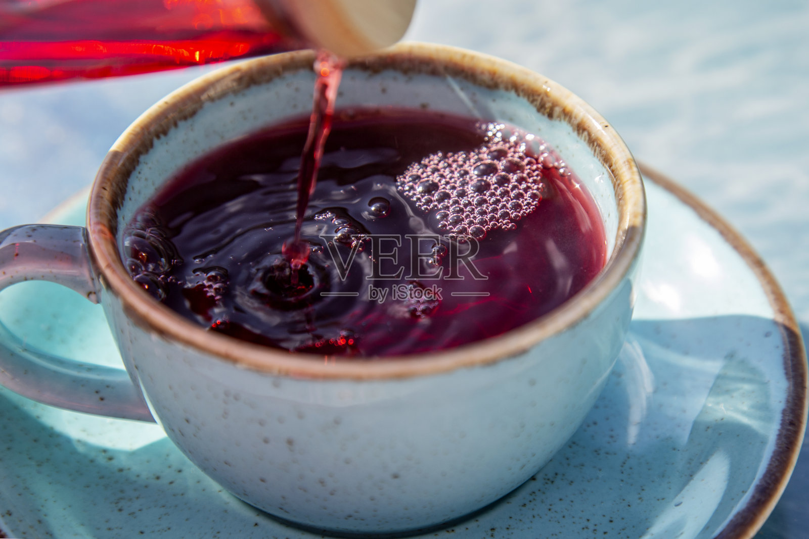 品红颜色的芙蓉茶在美丽的绿松石杯，户外照片摄影图片