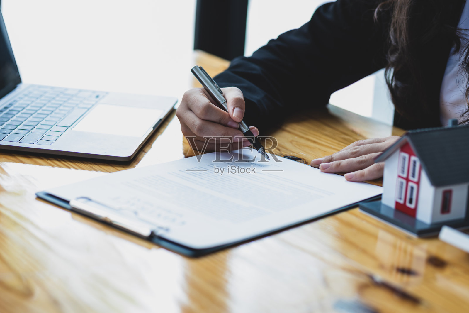 女商人，房地产经纪人阅读文件并合法签署合同协议。照片摄影图片