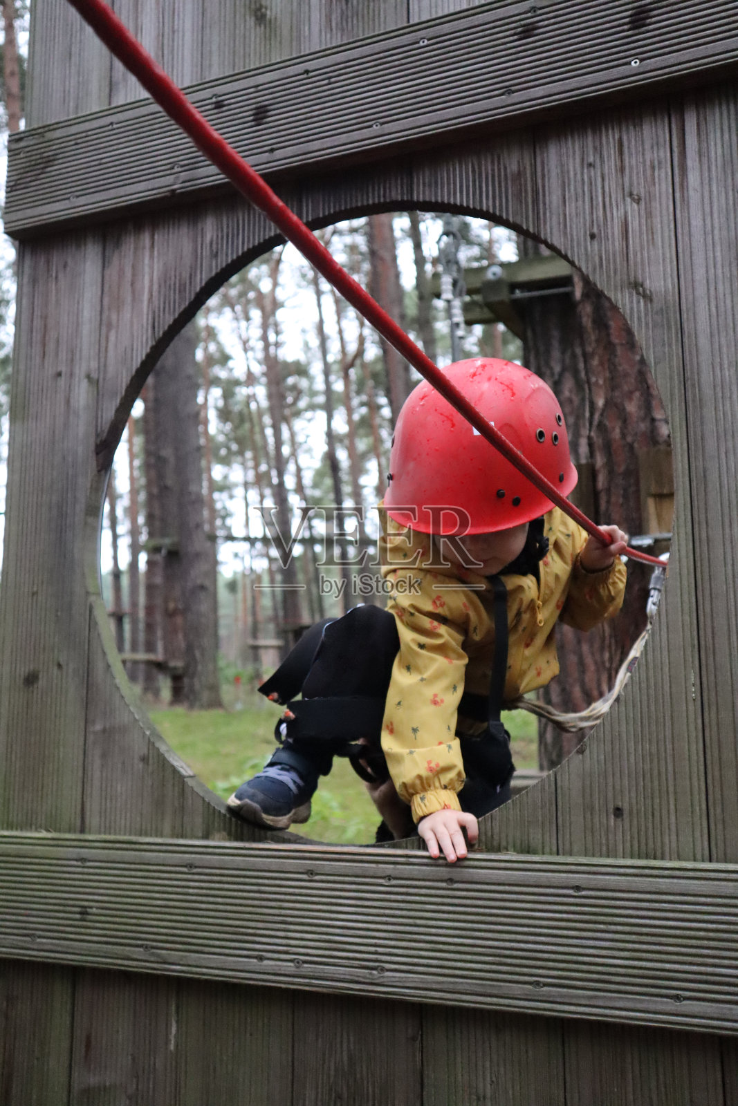 一个戴着红色头盔的小男孩正在进行攀岩运动照片摄影图片