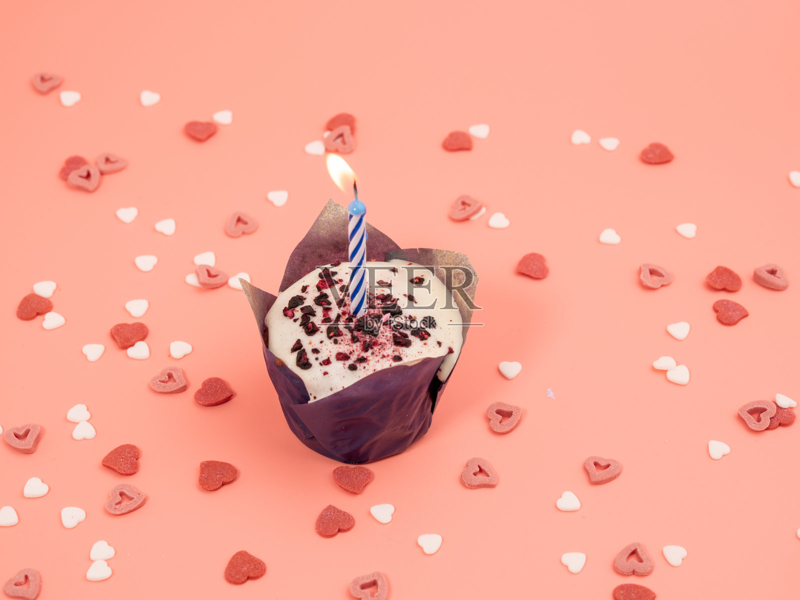 粉色背景上有蜡烛的松饼。假日松饼。照片摄影图片