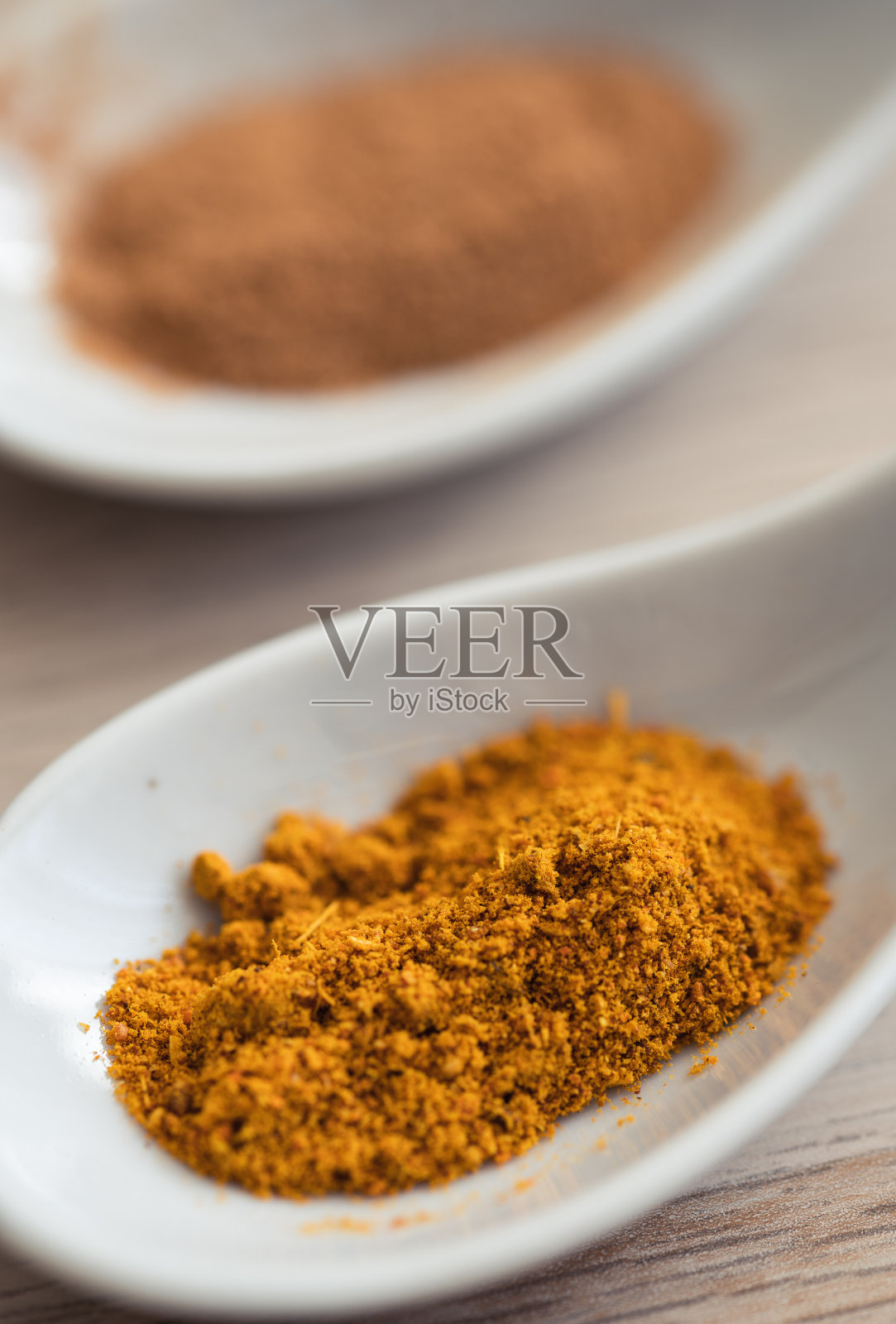 近距离观察两勺香料。肉桂和印度咖喱照片摄影图片