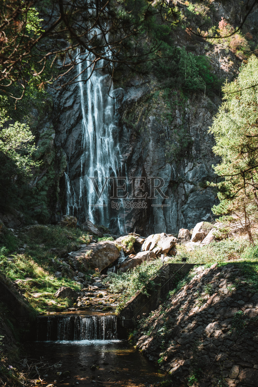 树木环绕的雄伟瀑布照片摄影图片
