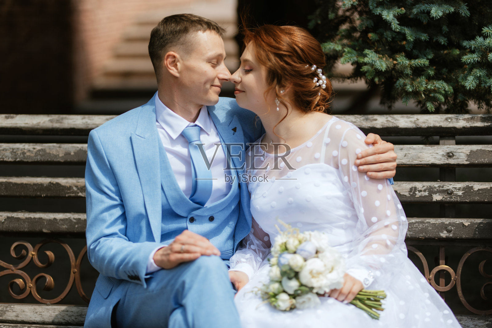 新娘身穿浅色婚纱，新郎身穿蓝色西装照片摄影图片