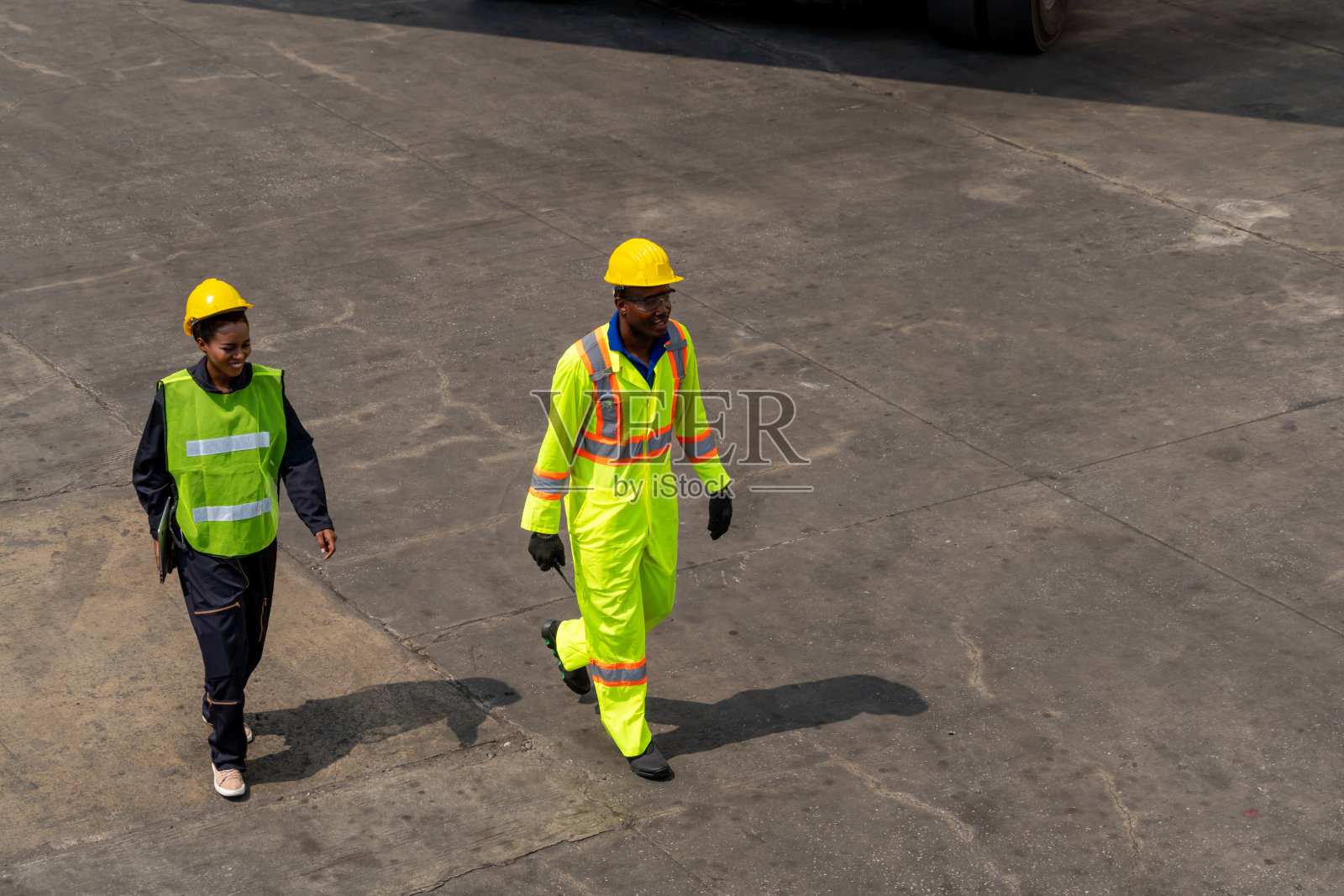 产业工人在海外集装箱堆场与同事一起工作。物流供应链管理与国际货物出口概念。照片摄影图片