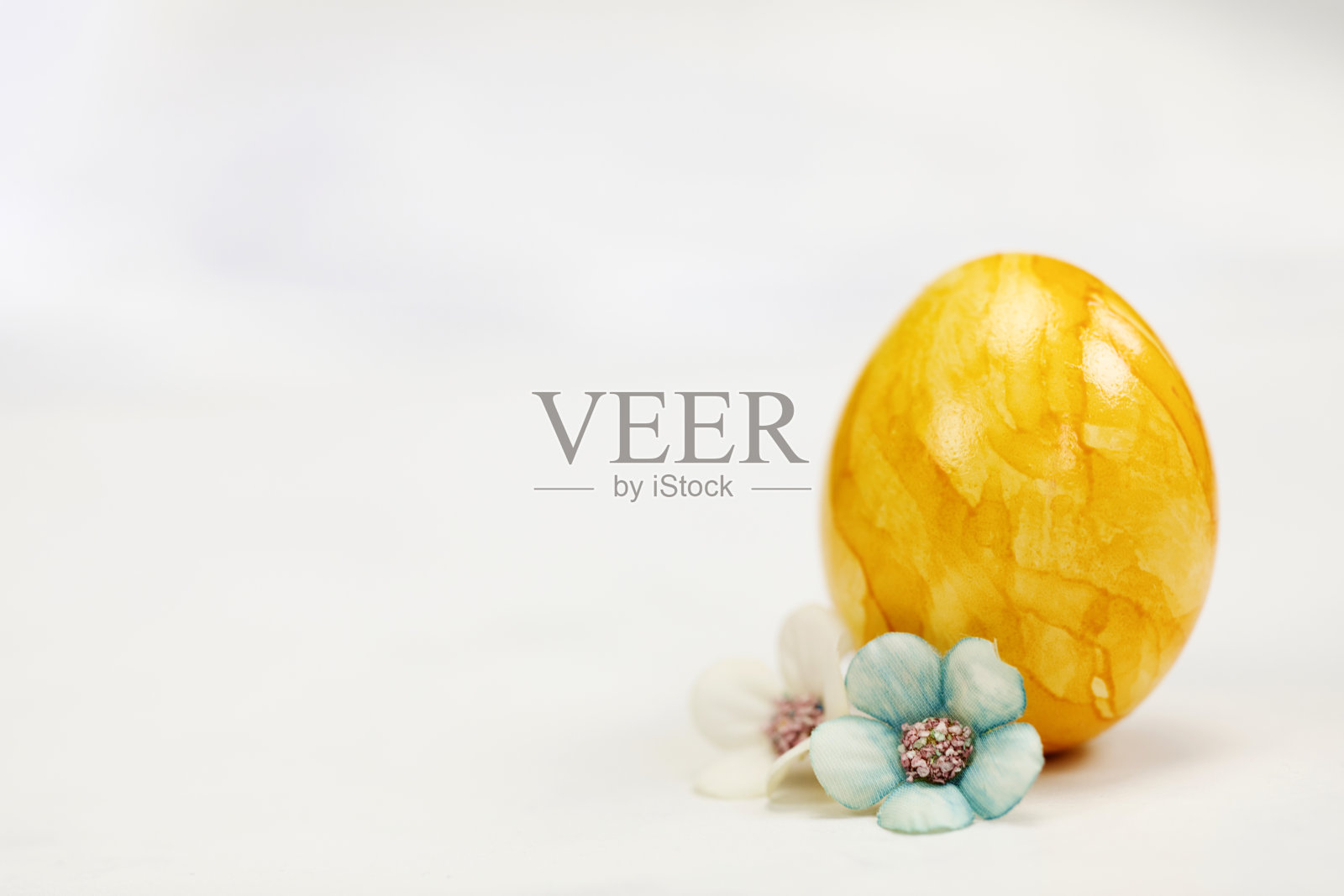 复活节彩蛋用柔和的颜色涂在白色背景上，复制空间和可爱的春天花朵，快乐的复活节假期概念与文本空间。黄色、粉色和蓝色照片摄影图片