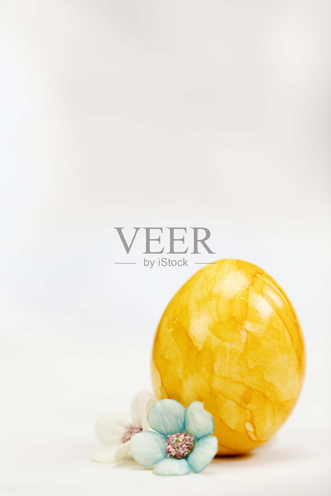 复活节彩蛋用柔和的颜色涂在白色背景上，复制空间和可爱的春天花朵，快乐的复活节假期概念与文本空间。黄色、粉色和蓝色照片摄影图片