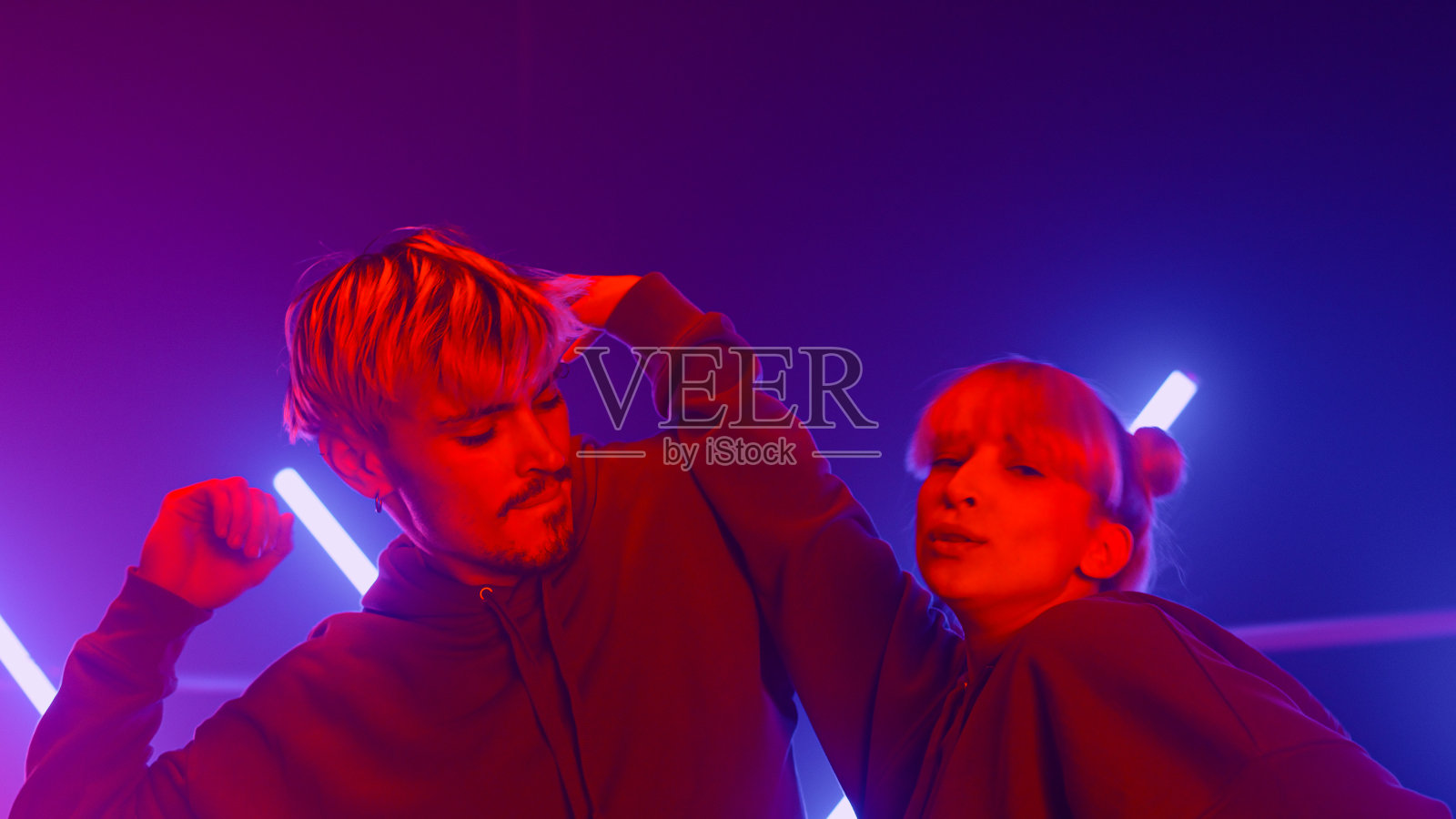 时髦的情侣在紫外线背光下一起跳freestyle。照片摄影图片