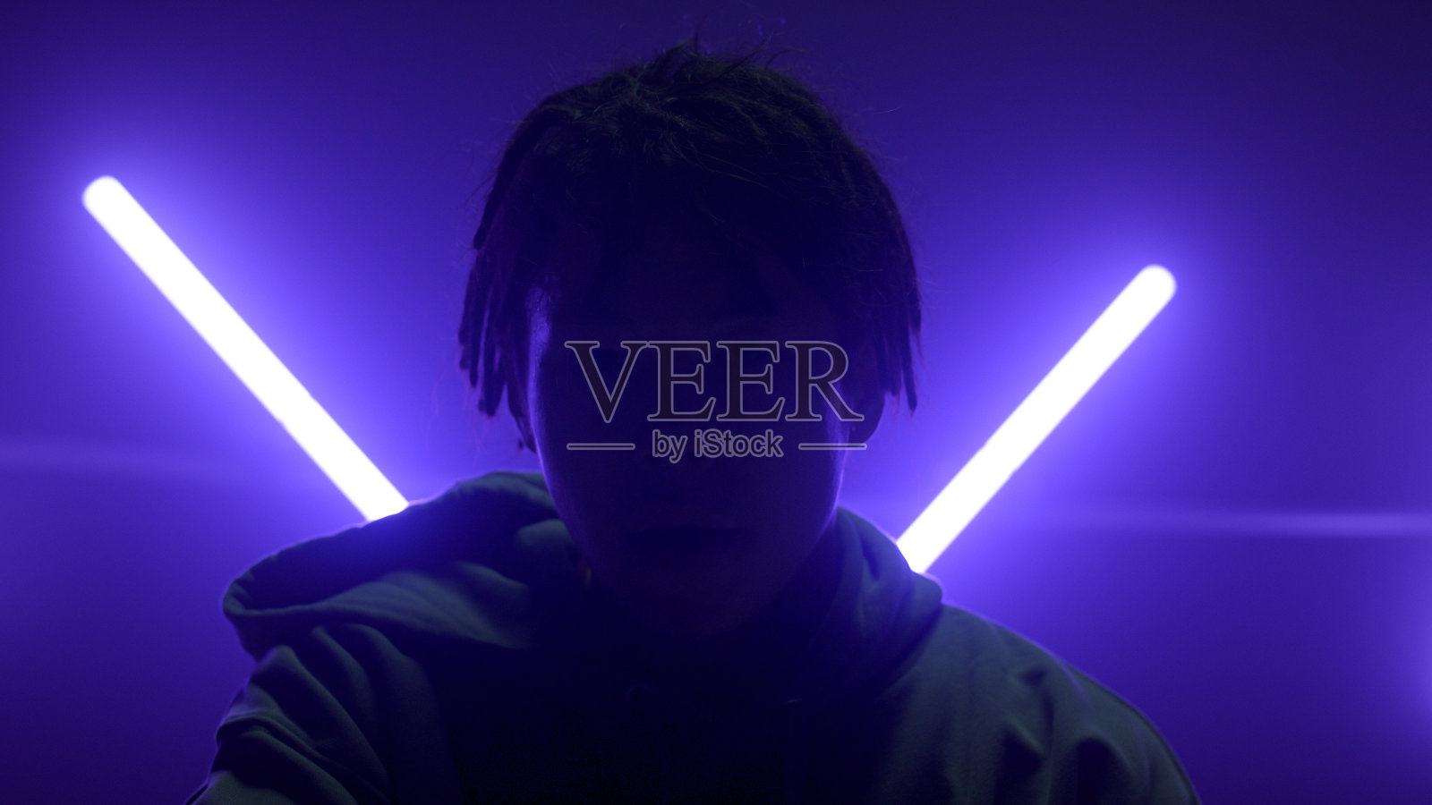 剪影男子摆出照明紫外线灯。可怕的家伙擦脸。照片摄影图片